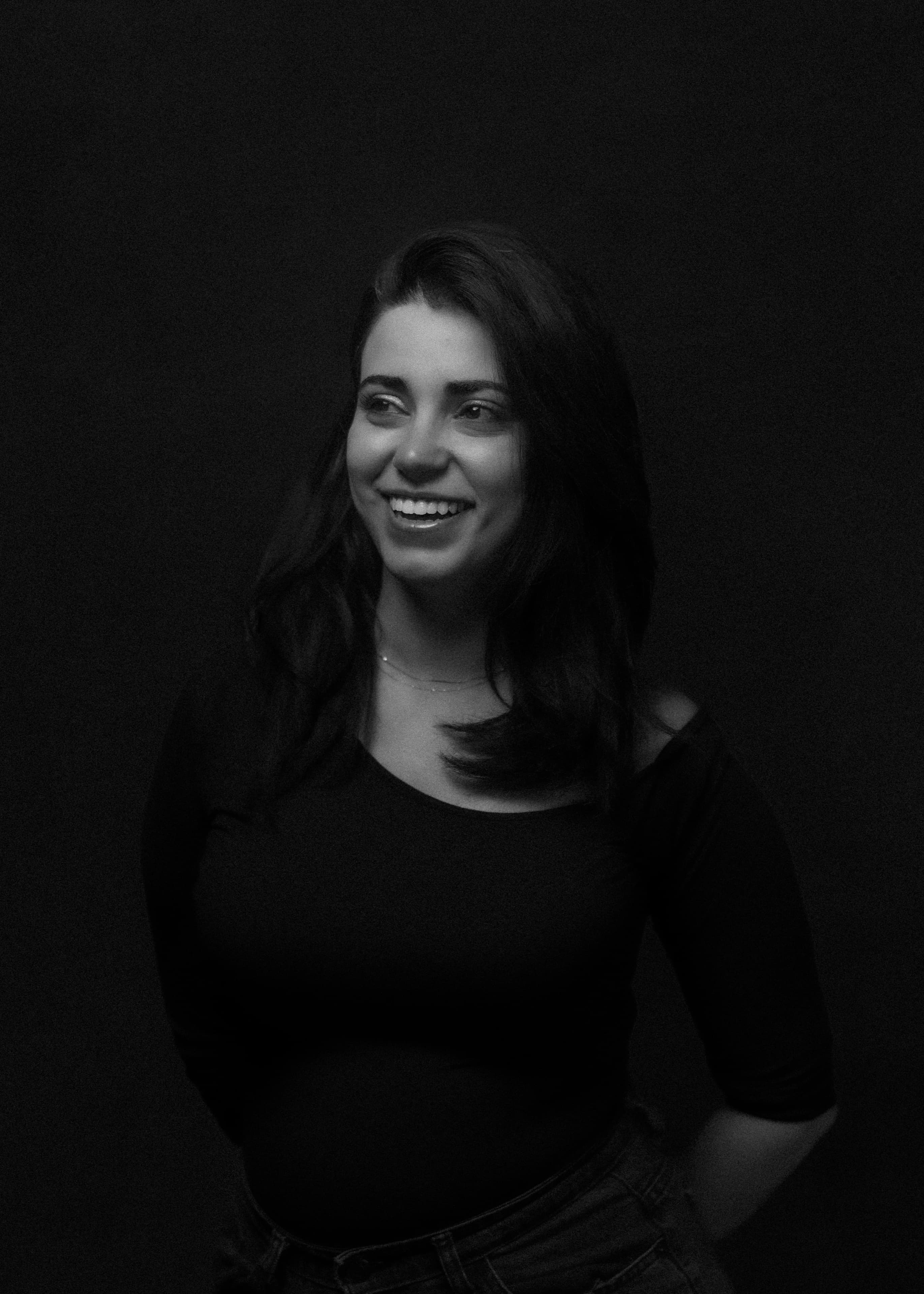 Black and white portrait of a woman laughing, glancing off camera