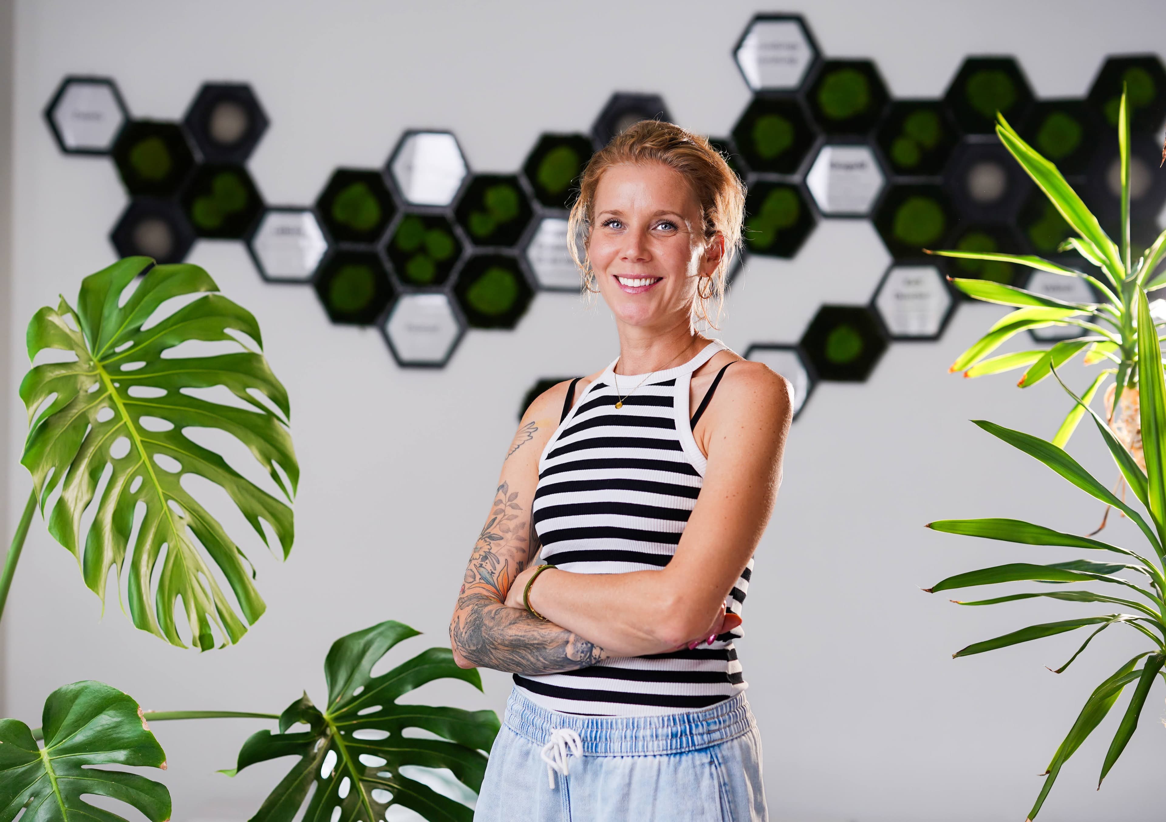 Environmental brand portrait in a modern office with a moss hexagon wall
