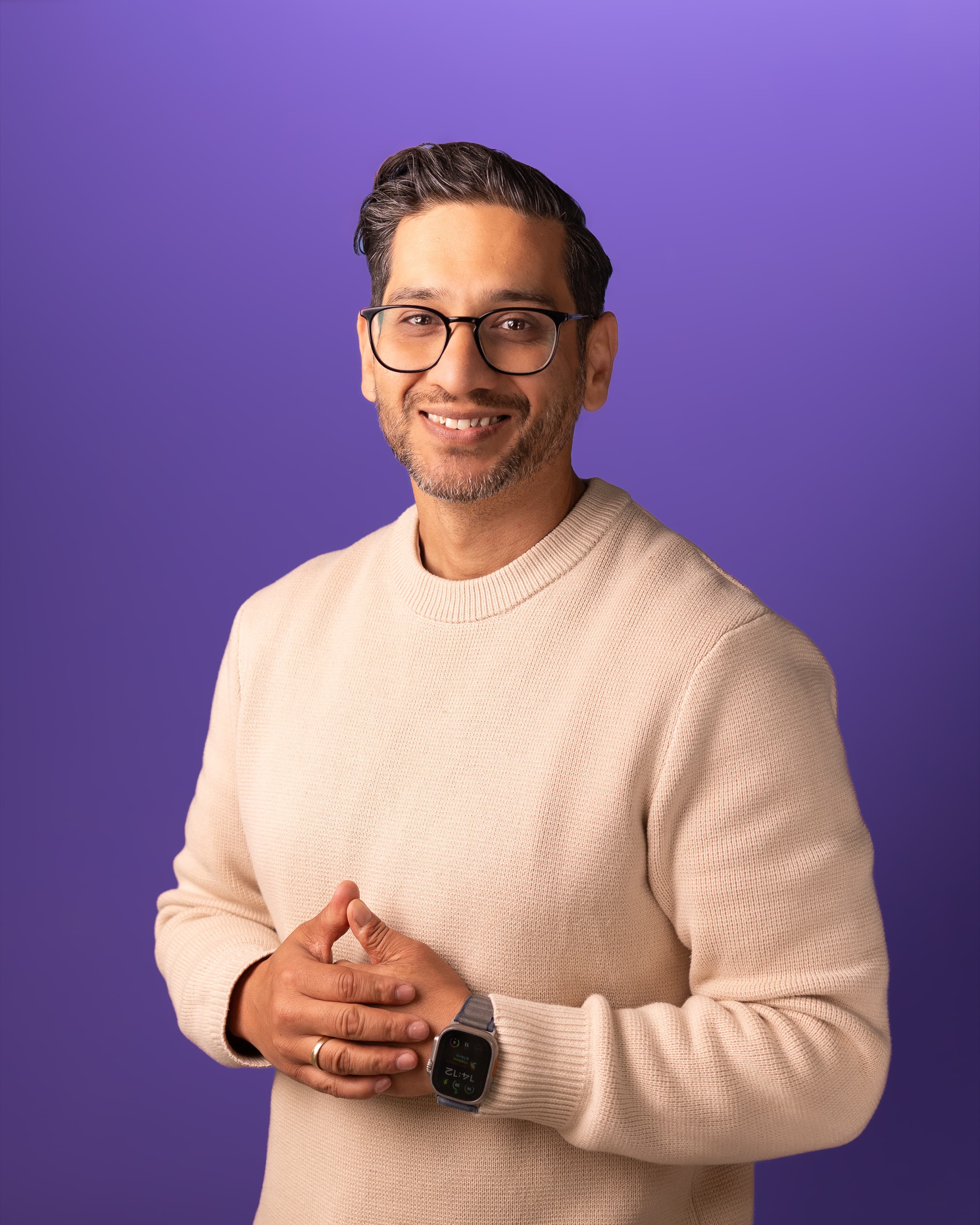 Tech founder headshot in a cream sweater against a violet backdrop