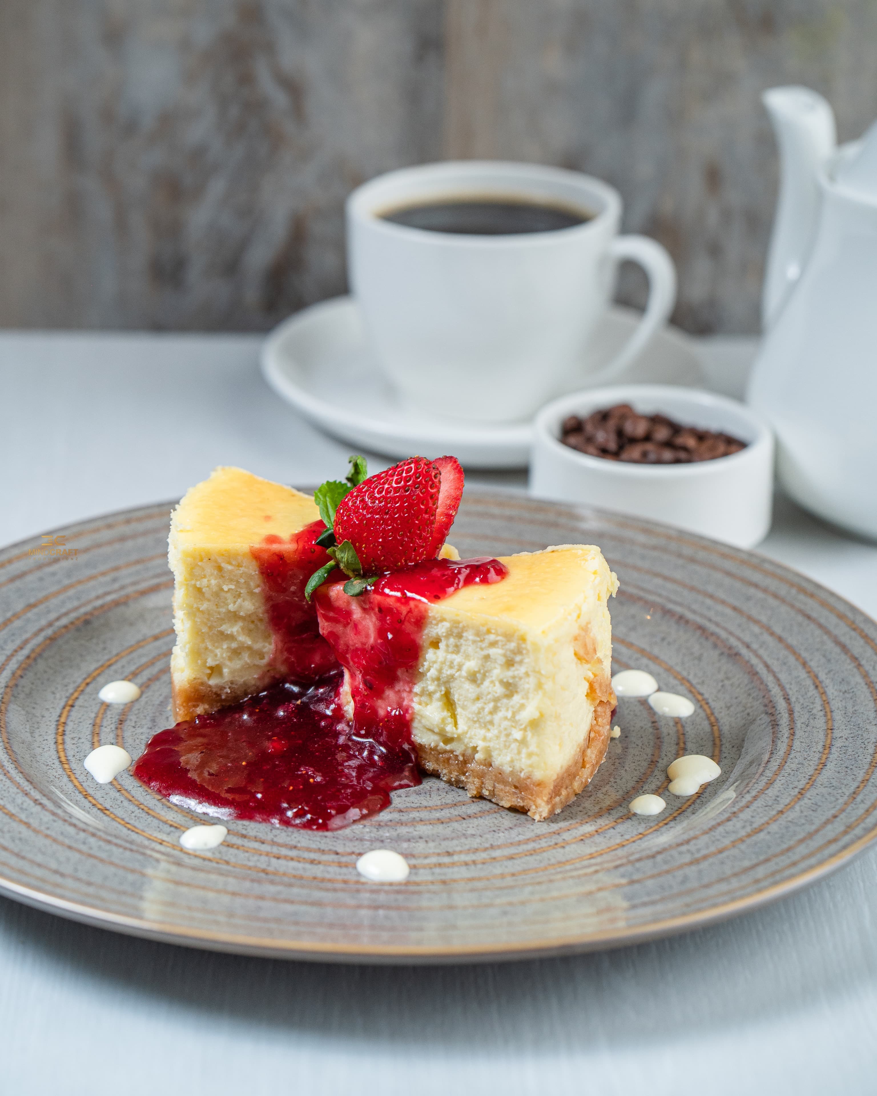 Baked cheesecake slice with berry coulis and coffee
