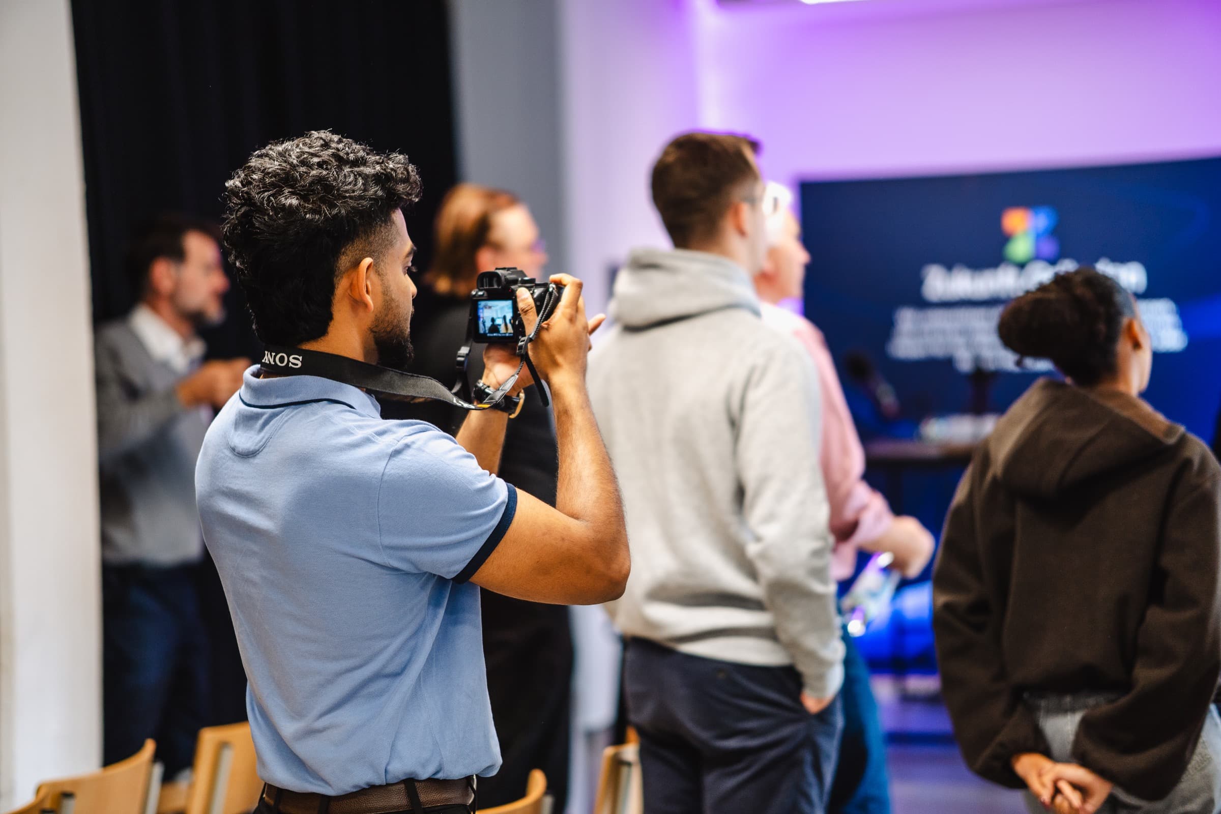 David photographing guests from within the crowd at a live event