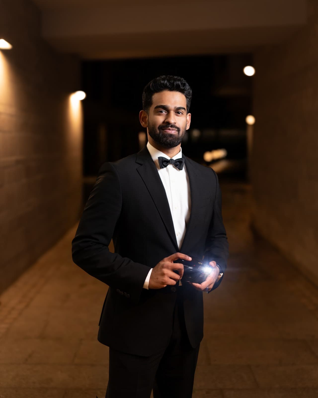 David George holding a camera in formal black tie