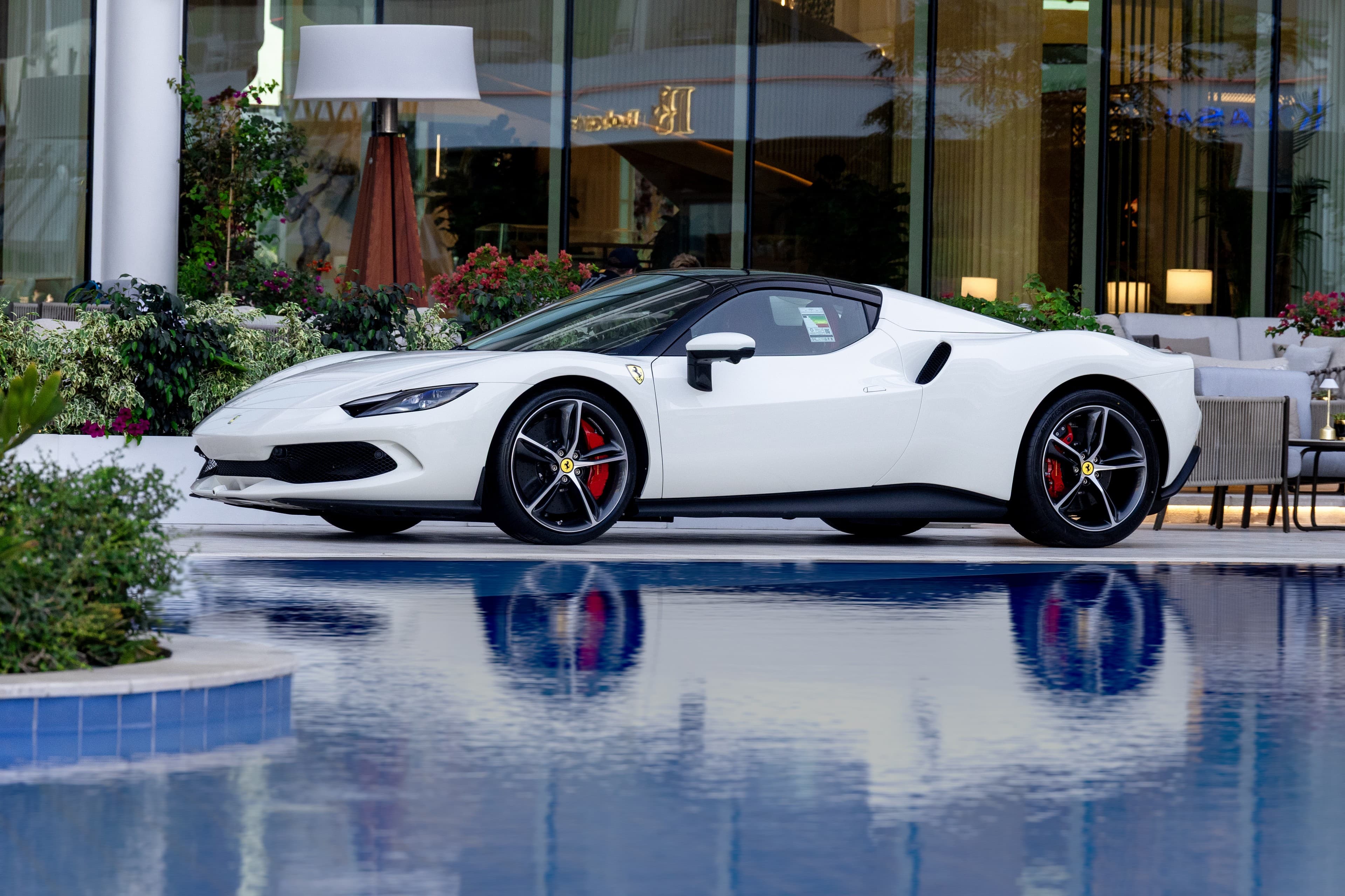 White Ferrari beside a reflecting pool