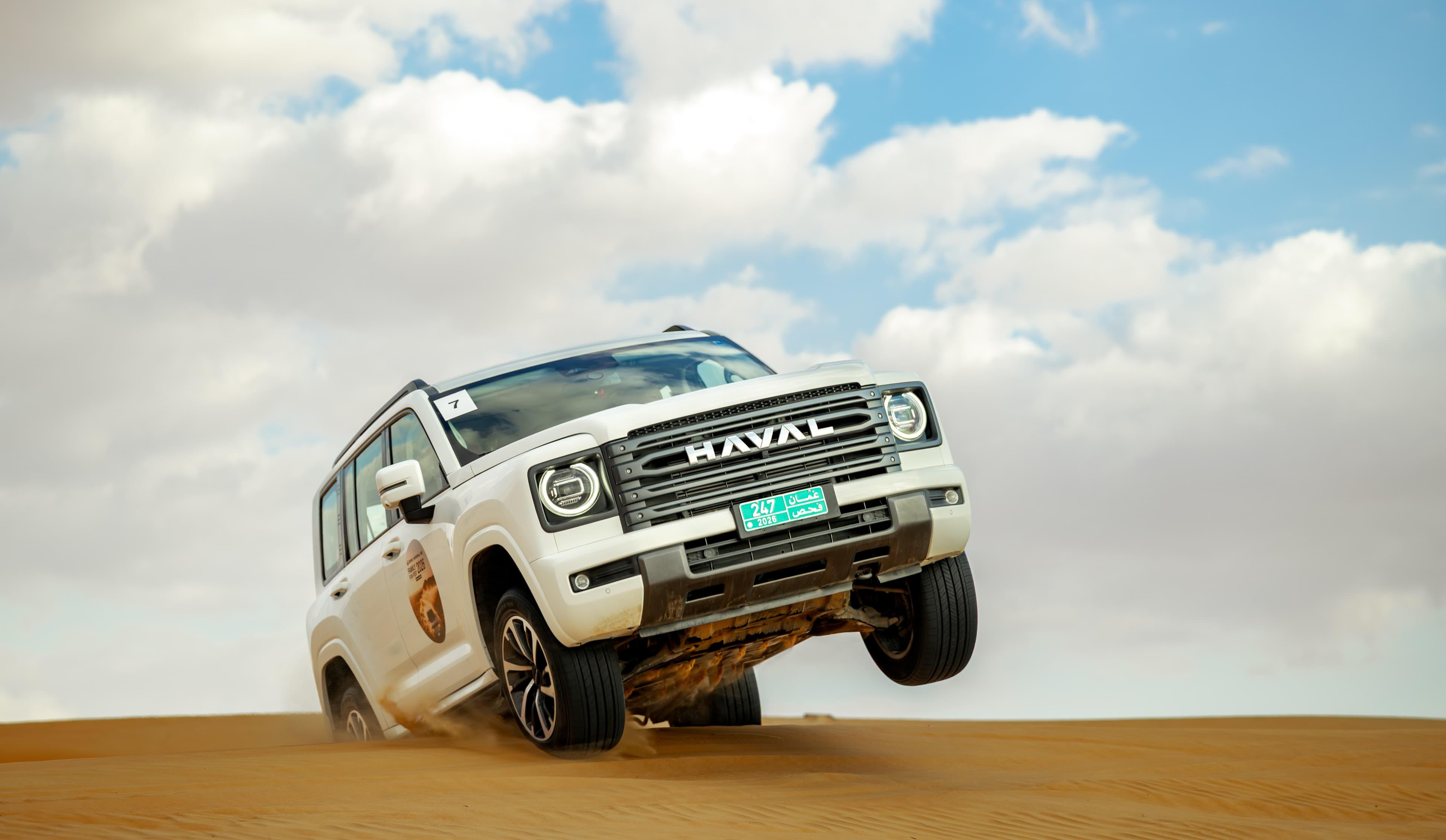 White SUV lifting over a dune